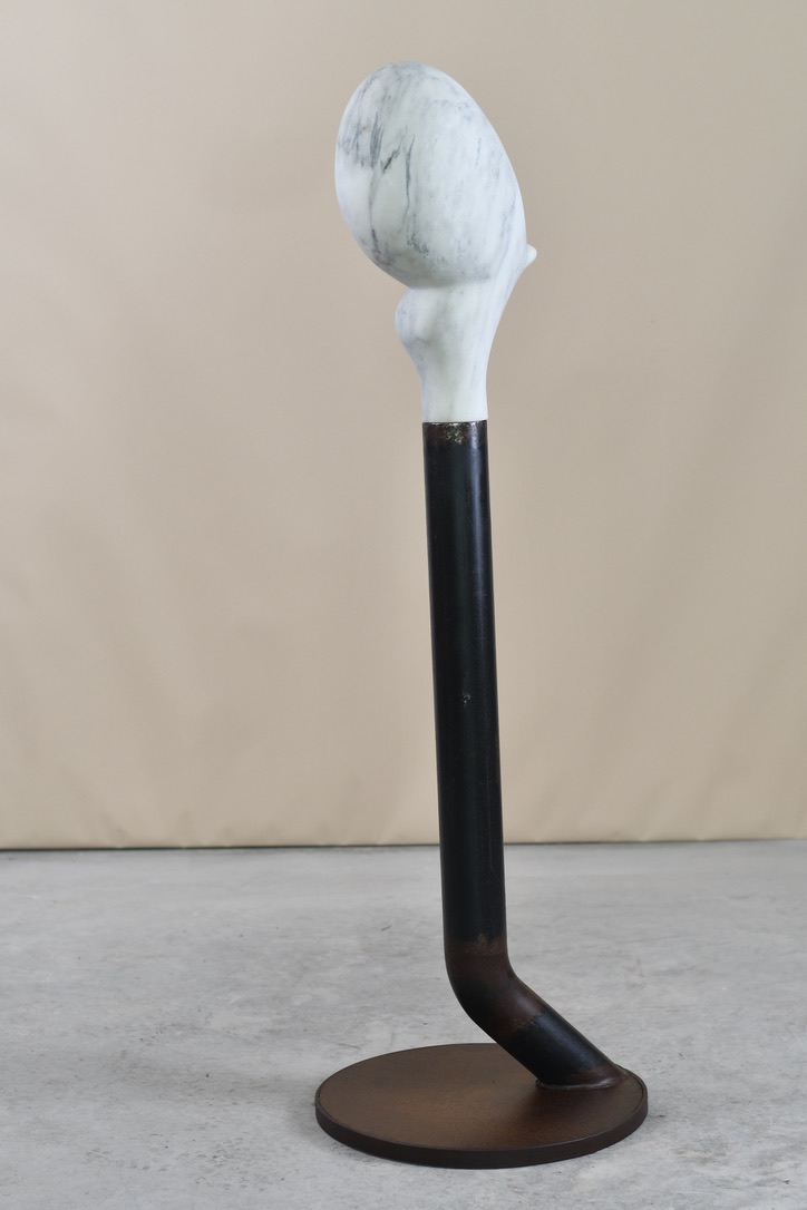 Full view of Maybe, Jay Swift’s 2026 marble and steel sculpture, measuring 58 × 18 × 18 inches, with the carved marble form elevated on a curved steel base.